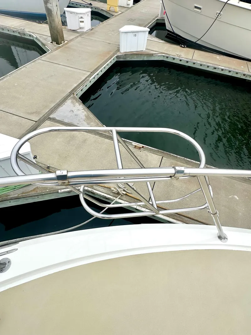 Slide: The Image of 1975 Hatteras Sport Fisher boat docked at marina with metal railing. - 33