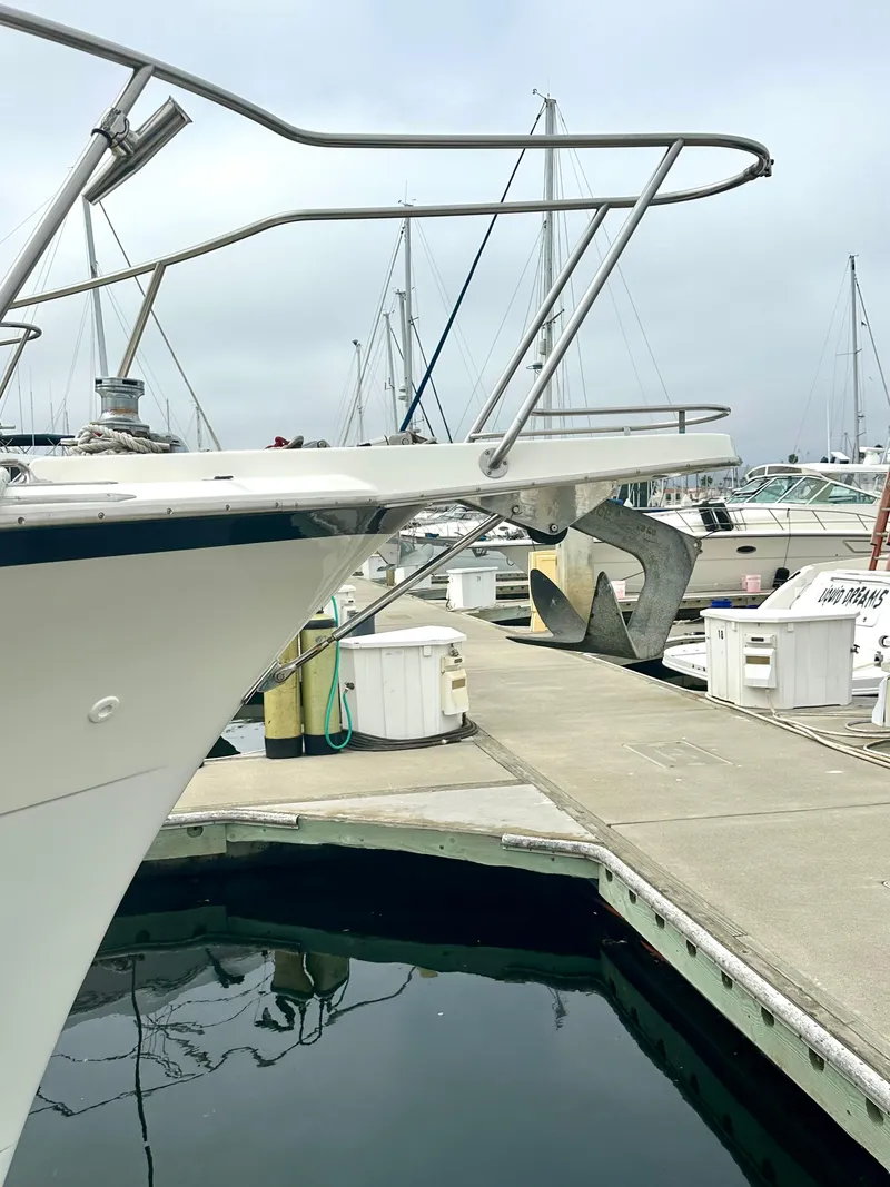 Slide: The Image of 1975 Hatteras Sport Fisher boat docked at marina, featuring anchor and railing. - 34