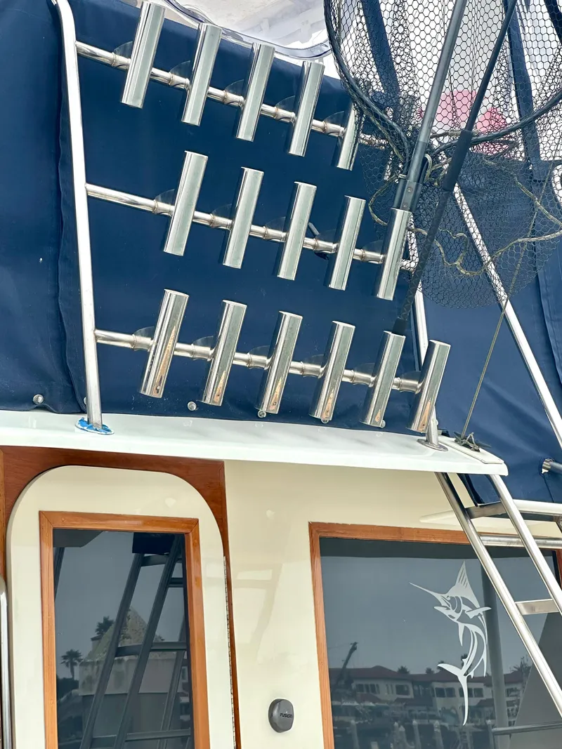 Slide: The Image of 1975 Hatteras Sport Fisher boat with rod holders and fishing net. - 42