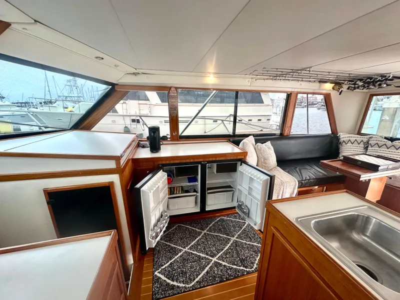 Slide: The Image of Interior of a 1975 Hatteras Sport Fisher yacht with open fridge and cozy seating area. - 7