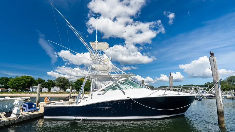 The Image of 2008 Cabo 38 Express boat docked under a bright blue sky with clouds. - 0