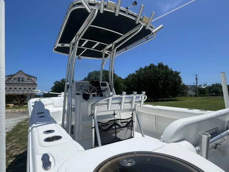 Slide: The Image of 2014 Sea Fox COMMANDER boat with T-top and console, parked outdoors under clear blue sky. - 10