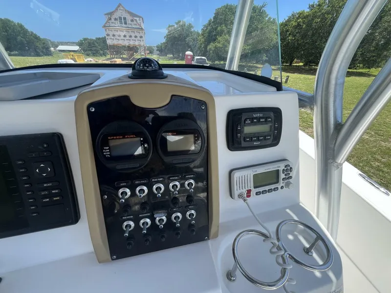 Slide: The Image of 2014 Sea Fox COMMANDER dashboard with gauges and controls, set against a scenic outdoor backdrop. - 25