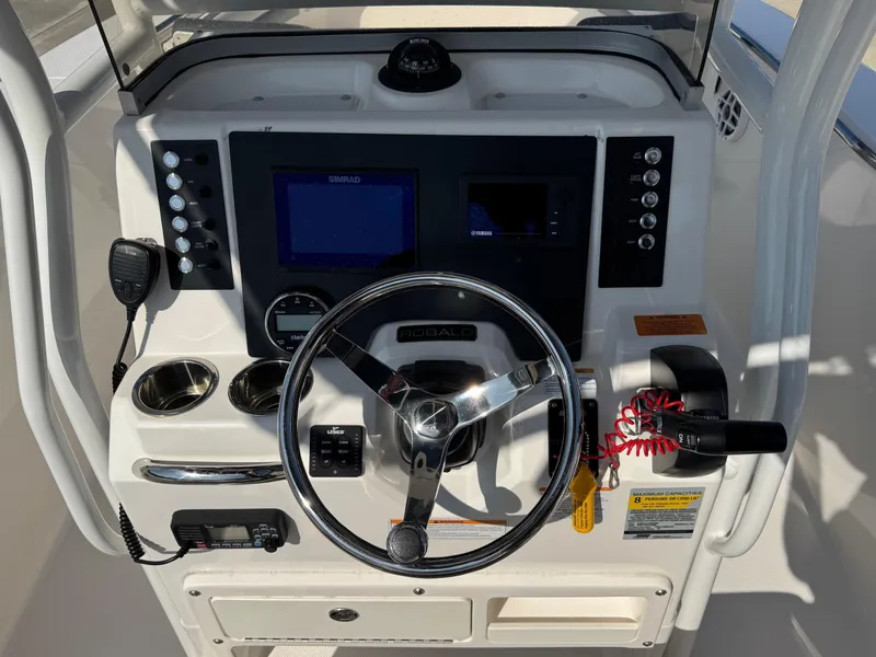 Slide: The Image of 2023 Robalo R202 Explorer boat dashboard with steering wheel and control panel. - 10