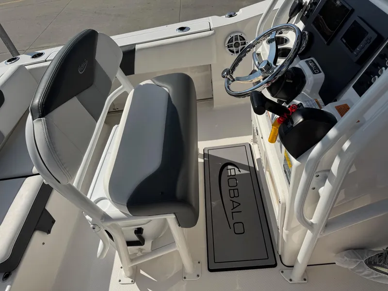 Slide: The Image of 2023 Robalo R202 Explorer boat interior with steering wheel and seating. - 12