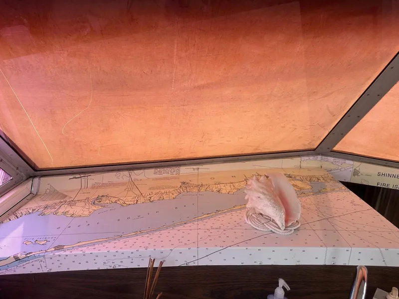 Slide: The Image of Nautical chart with conch shell on 1978 Bertram 33 Convertible boat interior. - 18