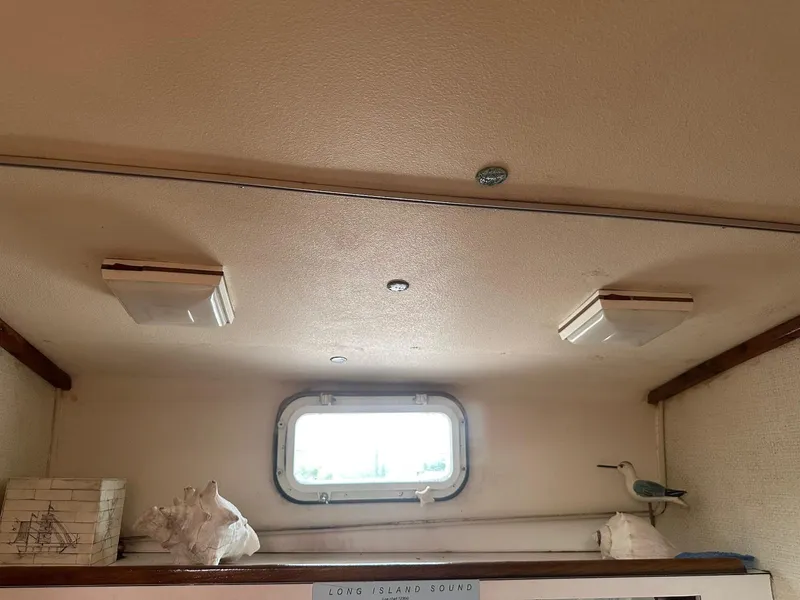 Slide: The Image of Interior of a 1978 Bertram 33 Convertible boat with decorative items and a window. - 24