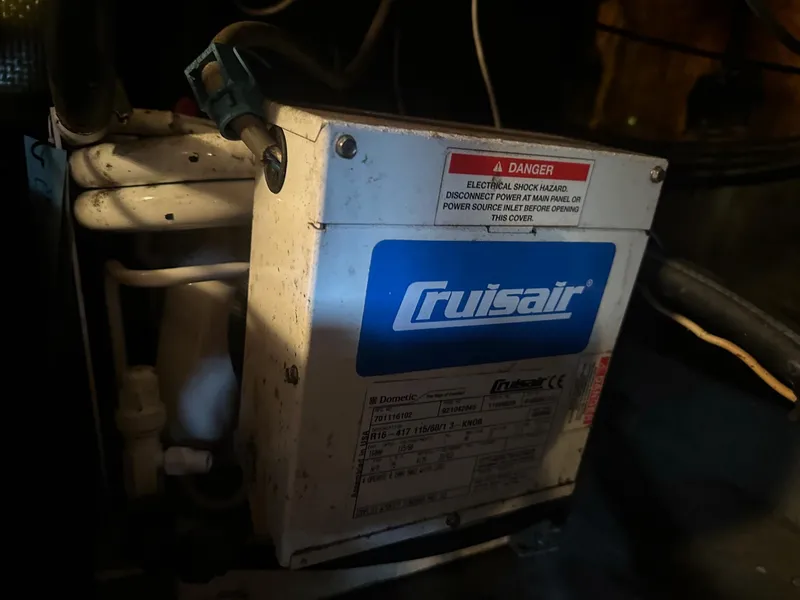 Slide: The Image of Cruisair unit inside a 1978 Bertram 33 Convertible boat, showing electrical warning label. - 25