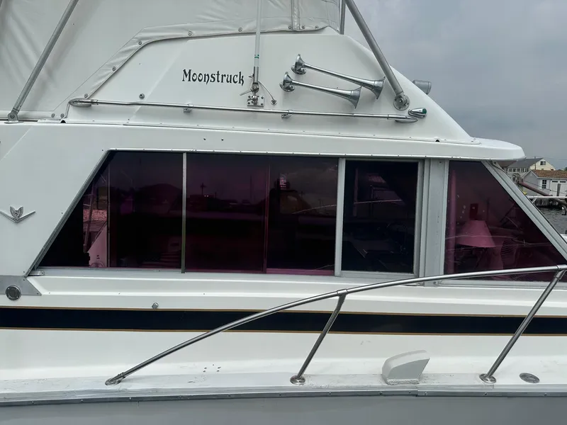Slide: The Image of 1978 Bertram 33 Convertible boat named "Moonstruck" with tinted windows and chrome details. - 4