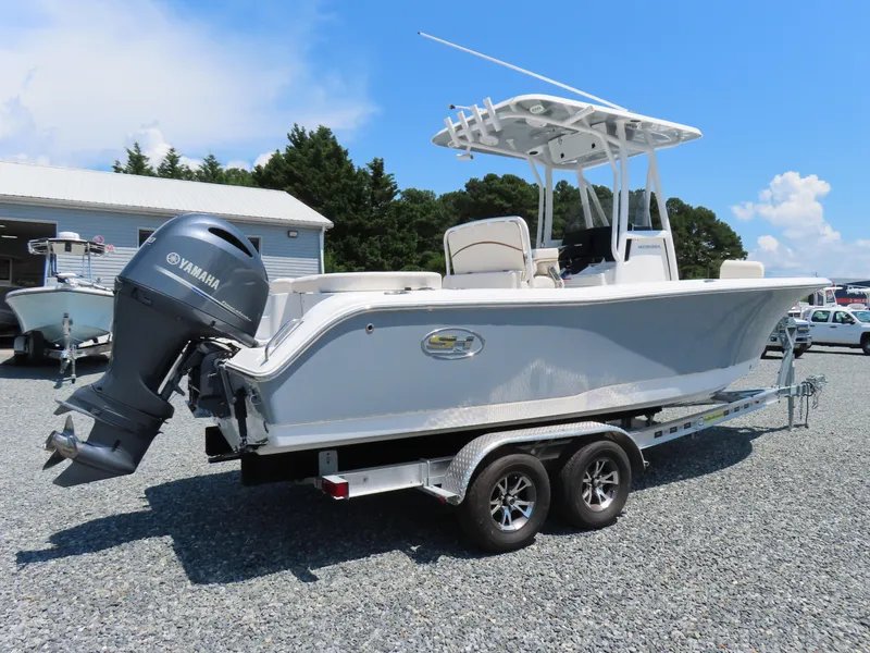 Slide: The Image of 2020 Sea Hunt Ultra 234 boat on trailer with Yamaha outboard motor, parked outdoors. - 2
