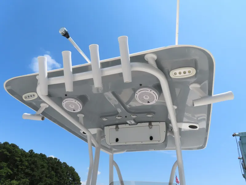 Slide: The Image of 2020 Sea Hunt Ultra 234 boat T-top with rod holders and speakers against blue sky. - 29