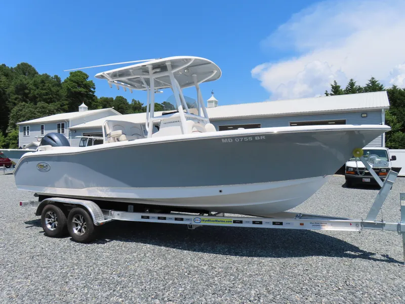 Slide: The Image of 2020 Sea Hunt Ultra 234 boat on trailer, parked outdoors under clear blue sky. - 3