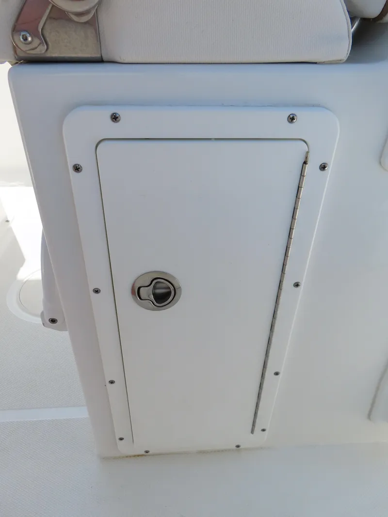 Slide: The Image of 2020 Sea Hunt Ultra 234 boat storage compartment with latch and hinge detail. - 32