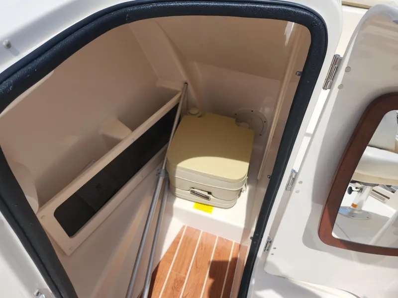 Slide: The Image of 2018 Grady-White Freedom 215 boat interior with compact toilet and storage area. - 16