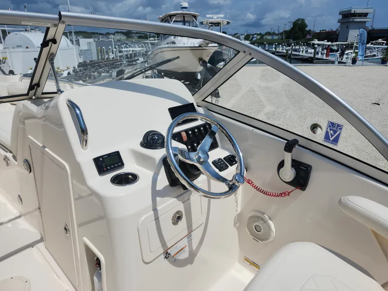 Slide: The Image of 2018 Grady-White Freedom 215 boat dashboard with steering wheel and controls at marina. - 8