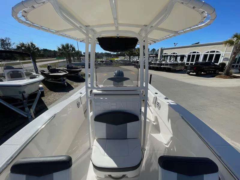 Slide: The Image of 2023 Robalo R202 Explorer boat with seating, docked at a marina under clear skies. - 5