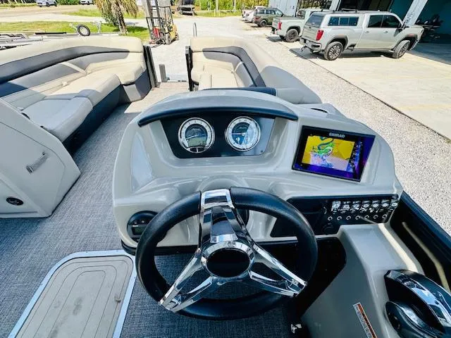 Slide: The Image of 2022 Barletta C24U boat dashboard with steering wheel and navigation display. - 14