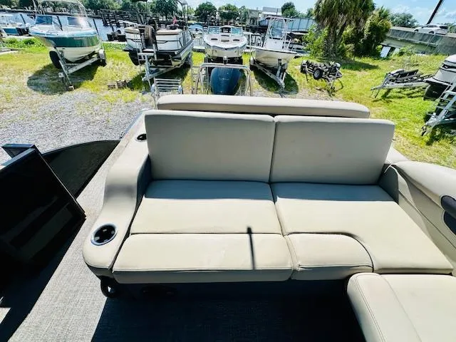 Slide: The Image of 2022 Barletta C24U pontoon boat with beige seating, docked near other boats. - 18