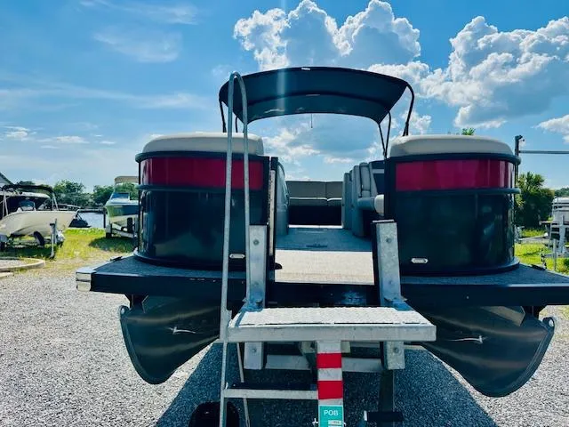 Slide: The Image of 2022 Barletta C24U pontoon boat with canopy, parked outdoors under a blue sky. - 6
