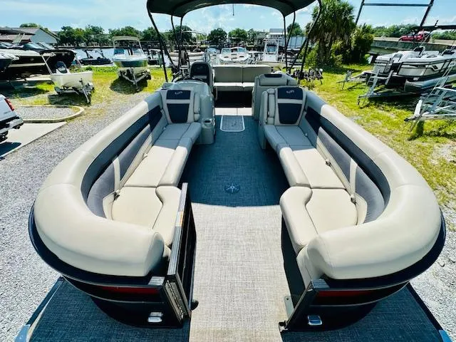 Slide: The Image of 2022 Barletta C24U pontoon boat with spacious seating, docked at a marina. - 7