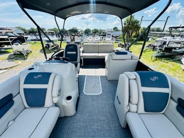 Slide: The Image of 2022 Barletta C24U pontoon boat with spacious seating and modern design at a marina. - 8