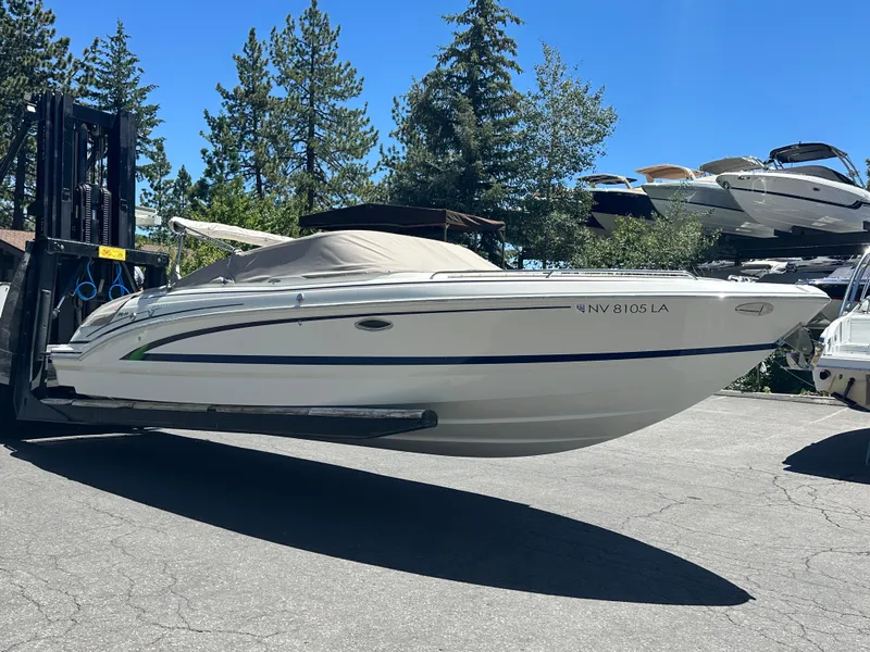 Slide: The Image of 2017 Formula 270 Bowrider boat on forklift, surrounded by trees and other boats. - 2