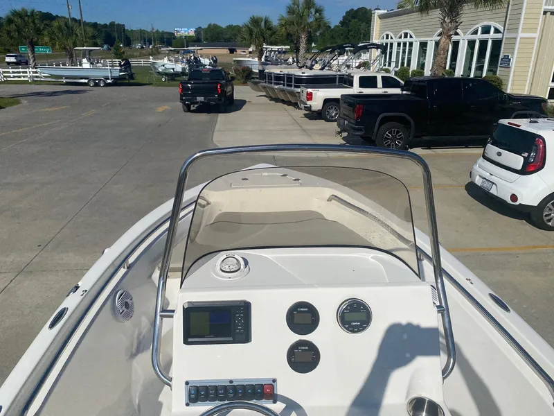 Slide: The Image of 2023 Key West 189 FS boat dashboard with gauges and controls, parked near vehicles. - 6