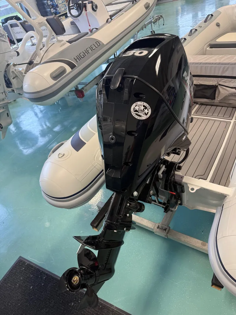 Slide: The Image of 2024 Highfield CL360 inflatable boat with a black outboard motor in a showroom. - 4