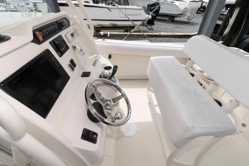 Slide: The Image of 2016 Sailfish 240 CC boat cockpit with steering wheel and control panel. - 12