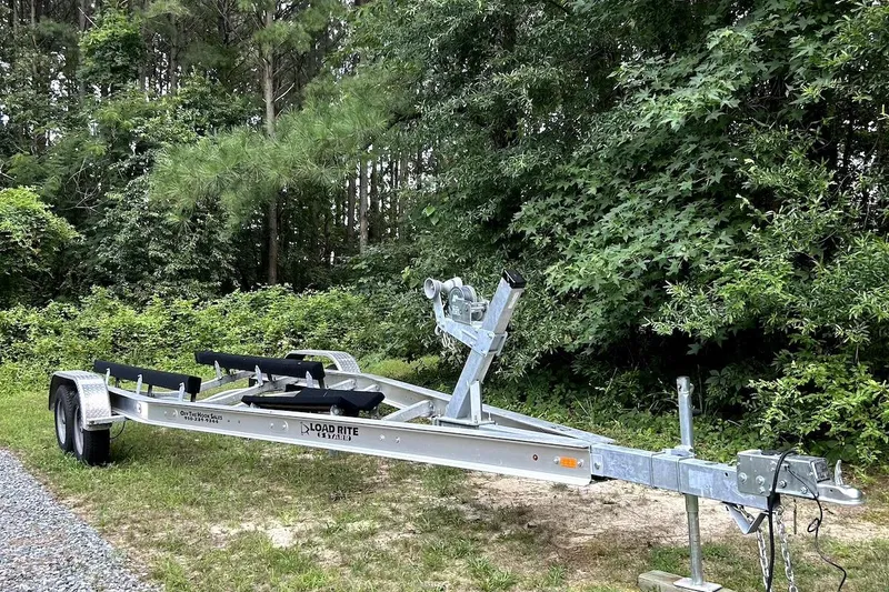 Slide: The Image of Boat trailer for 2016 Sailfish 240 CC, parked on grass near trees. - 13