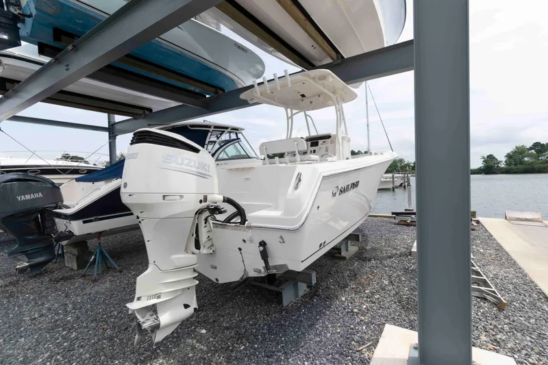 Slide: The Image of 2016 Sailfish 240 CC boat with Suzuki outboard motor, docked near water. - 4
