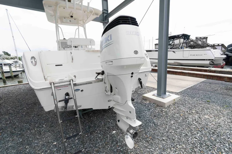 Slide: The Image of 2016 Sailfish 240 CC boat with Suzuki outboard motor, docked on gravel. - 5