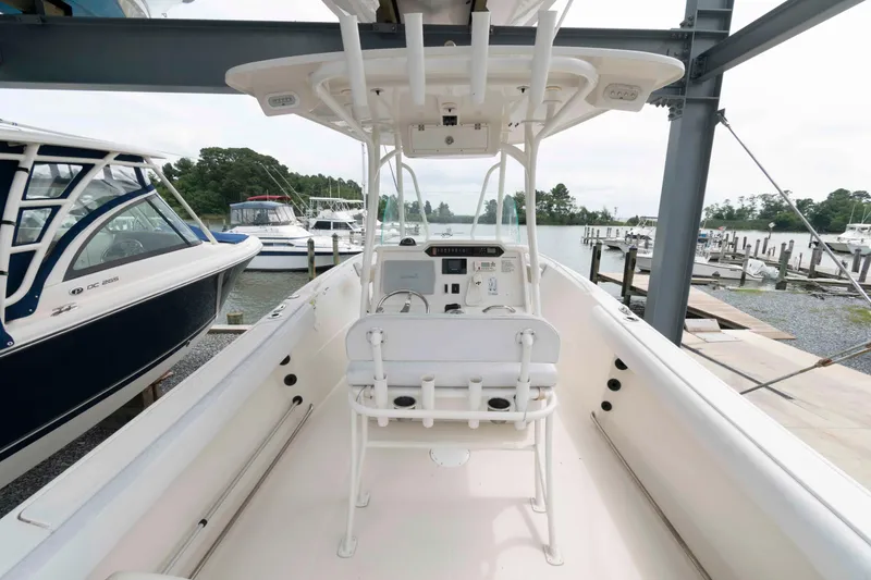 Slide: The Image of 2016 Sailfish 240 CC boat interior at marina, featuring helm and seating. - 7