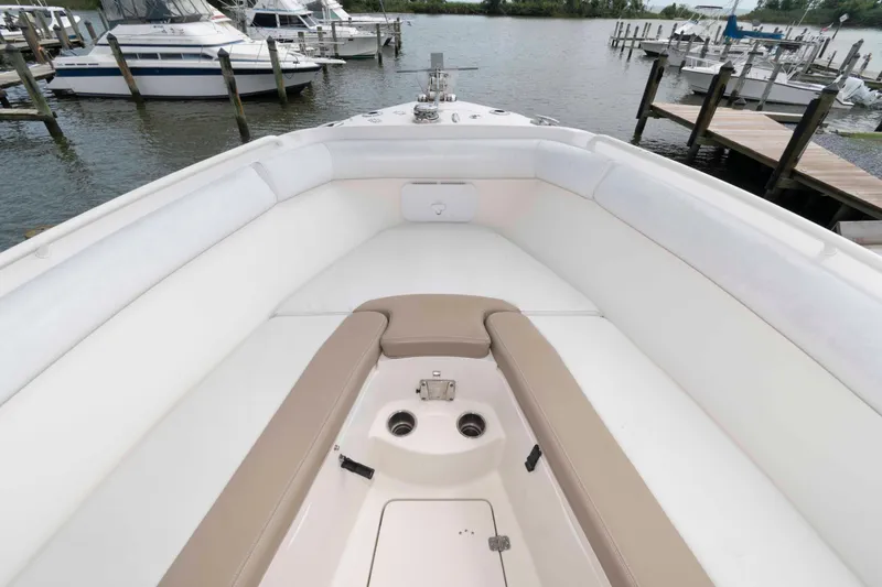 Slide: The Image of 2016 Sailfish 240 CC boat interior with white and beige seating at a marina. - 9