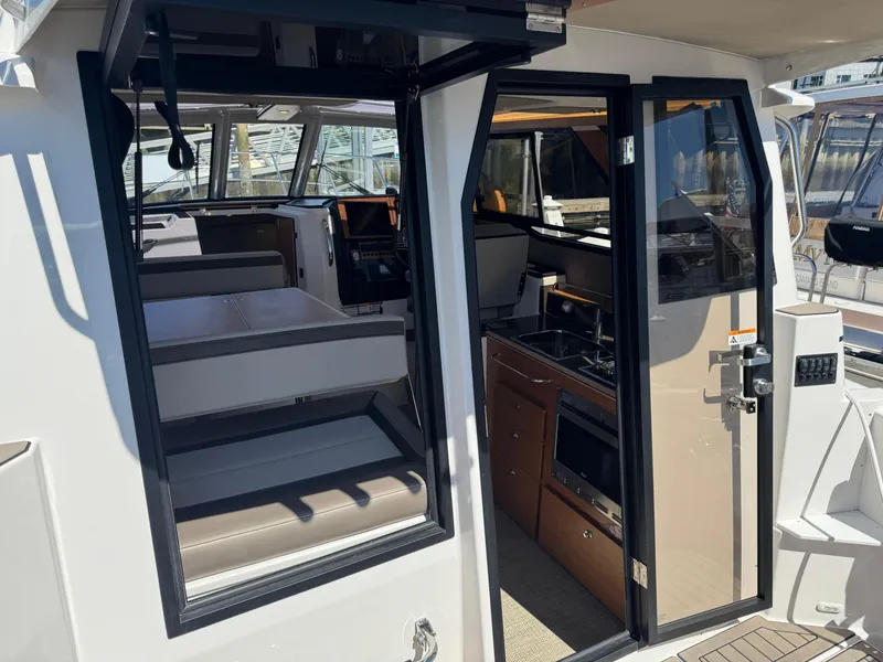 Slide: The Image of 2025 Cutwater C-288 Coupe interior with seating, kitchenette, and navigation area. - 7