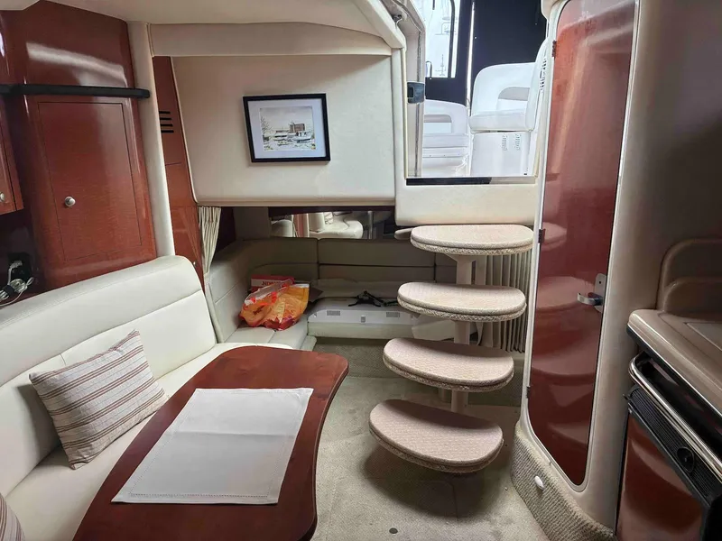 Slide: The Image of Interior of 2005 Sea Ray 320 Sundancer yacht with cozy seating and elegant wooden finishes. - 11