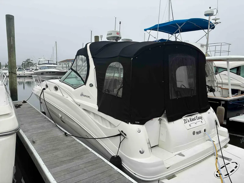 Slide: The Image of 2005 Sea Ray 320 Sundancer docked at marina with black canopy. - 2