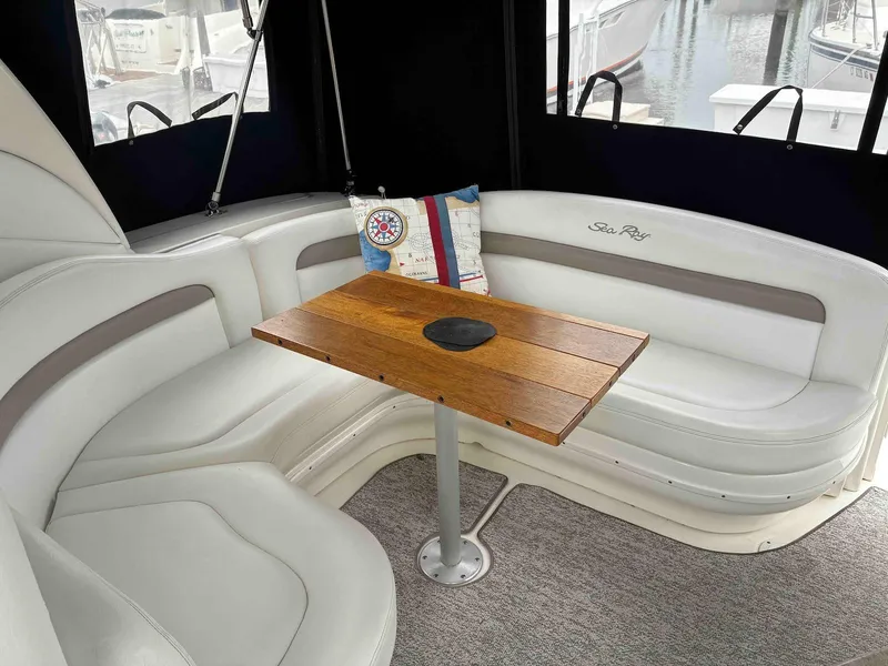 Slide: The Image of 2005 Sea Ray 320 Sundancer interior with white seating and wooden table. - 3
