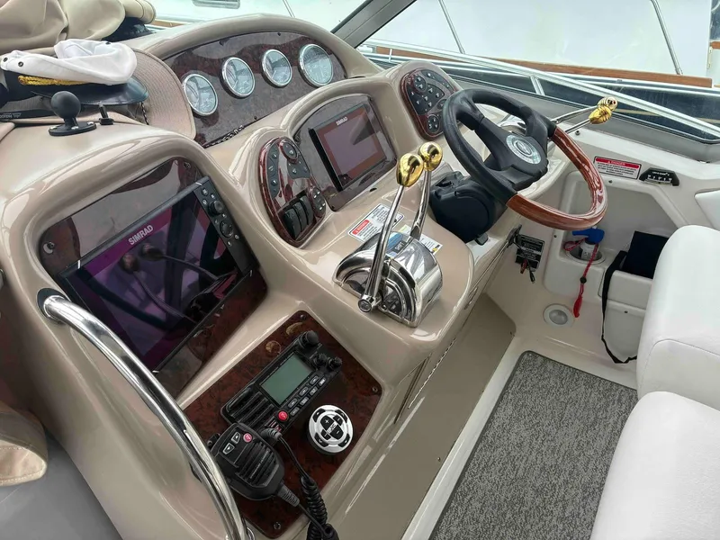 Slide: The Image of 2005 Sea Ray 320 Sundancer helm with navigation screens, steering wheel, and control panels. - 4