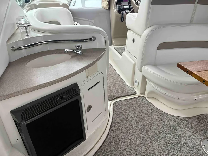 Slide: The Image of Interior of 2005 Sea Ray 320 Sundancer with sink, seating, and carpeted flooring. - 7