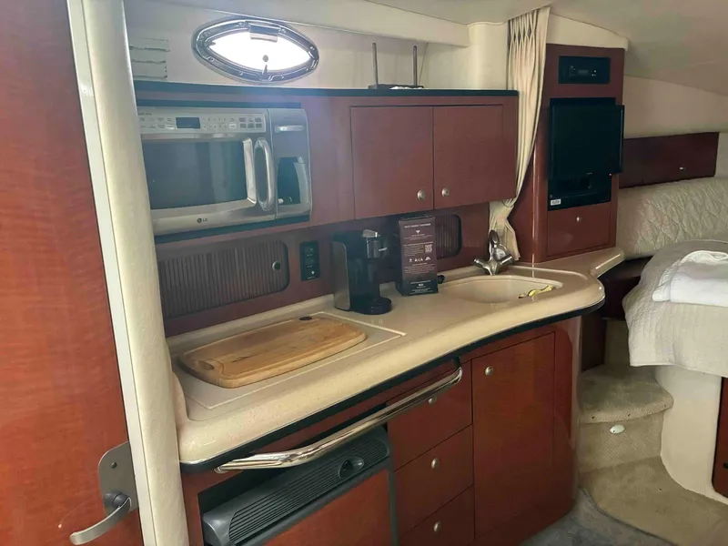 Slide: The Image of 2005 Sea Ray 320 Sundancer interior with kitchenette, microwave, and sink. - 9