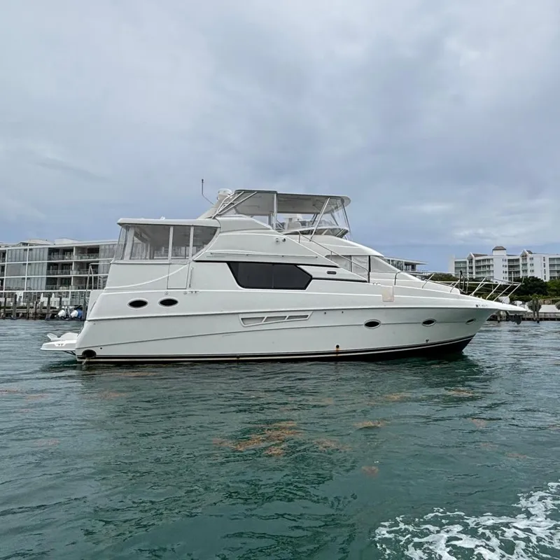 The Image of 2000 Silverton 453 Motor Yacht on calm water, with modern buildings in the background. - 0