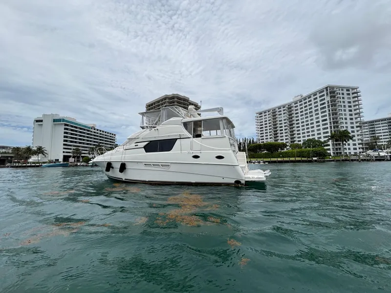 Slide: The Image of 2000 Silverton 453 Motor Yacht on water near modern buildings. - 2