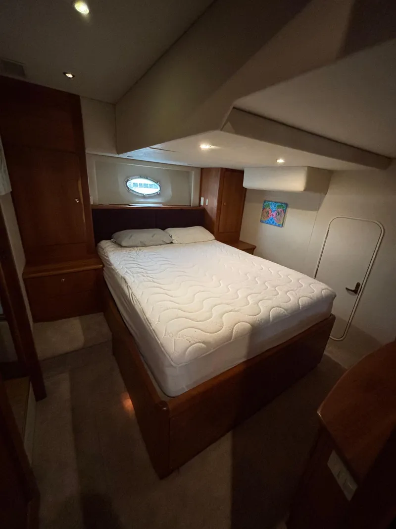 Slide: The Image of Interior of 2000 Silverton 453 Motor Yacht bedroom with bed and porthole window. - 29