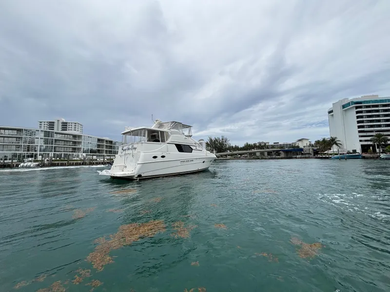 Slide: The Image of 2000 Silverton 453 Motor Yacht cruising near modern waterfront buildings. - 3