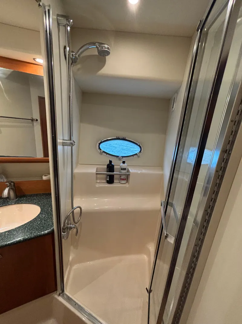 Slide: The Image of Bathroom interior of 2000 Silverton 453 Motor Yacht with shower and porthole window. - 31