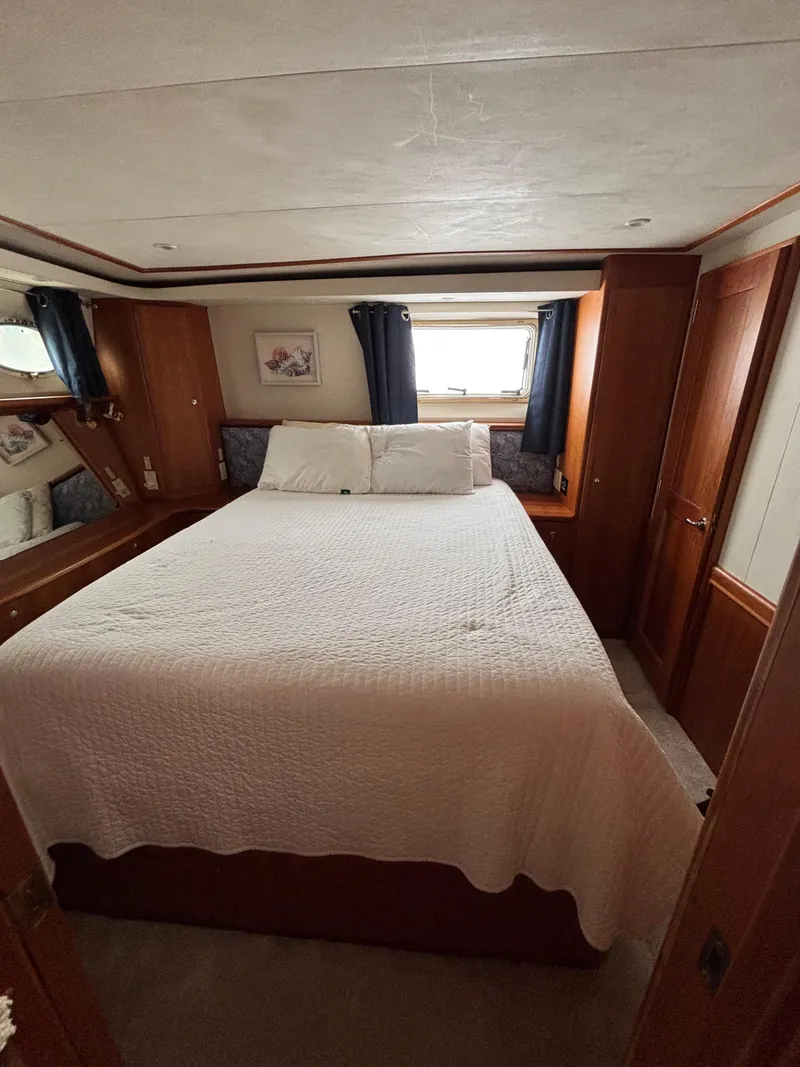 Slide: The Image of Interior of 2000 Silverton 453 Motor Yacht bedroom with bed and window. - 34