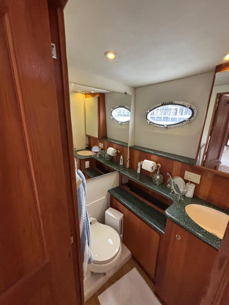 Slide: The Image of Luxurious bathroom in a 2000 Silverton 453 Motor Yacht with wood accents and oval windows. - 35