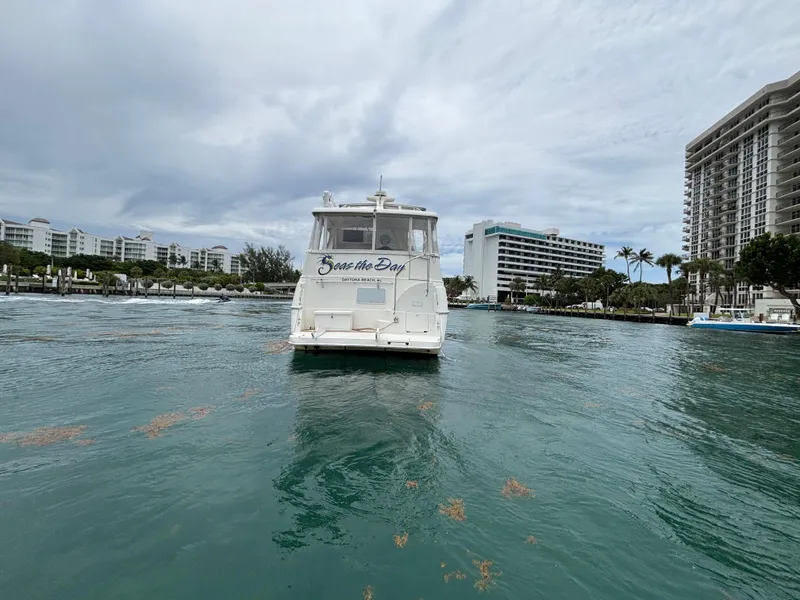 Slide: The Image of 2000 Silverton 453 Motor Yacht on waterway, surrounded by buildings and palm trees. - 4