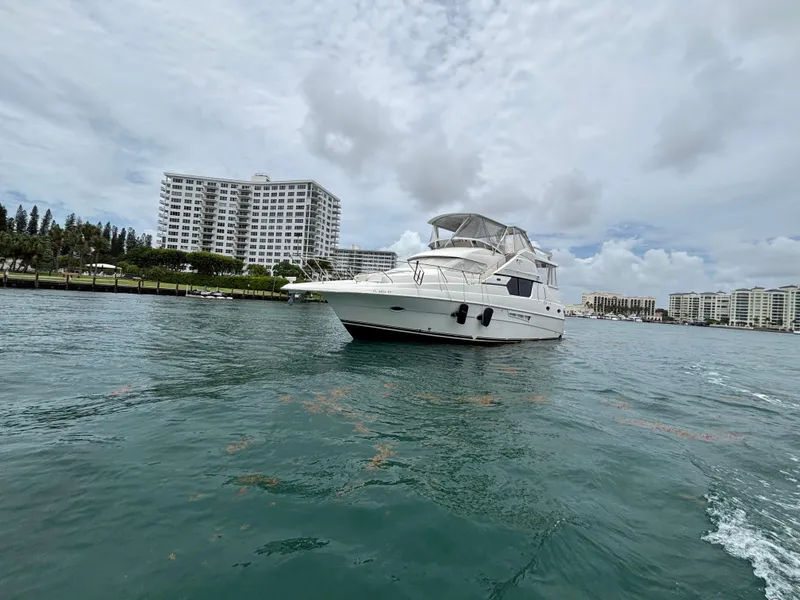 Slide: The Image of 2000 Silverton 453 Motor Yacht on water near coastal buildings under cloudy sky. - 8